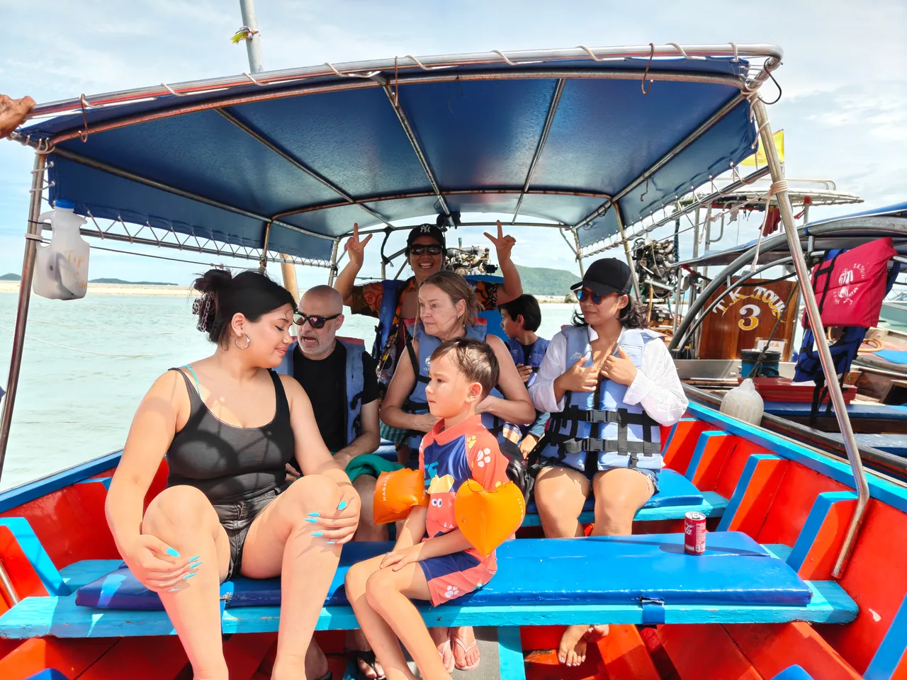 Passengers sitting under the canopy of a private longtail boat on a Pig Island trip